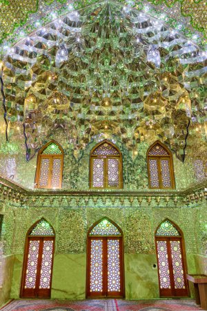Foto de Shiraz, Irán - 29 de octubre de 2018: Fabuloso interior de la sala de oración en el Santuario Ali Ibn Hamzeh Holly. Techo y paredes del lugar musulmán cubierto con azulejos de vidrio y espejo. Brillante mosaico. - Imagen libre de derechos