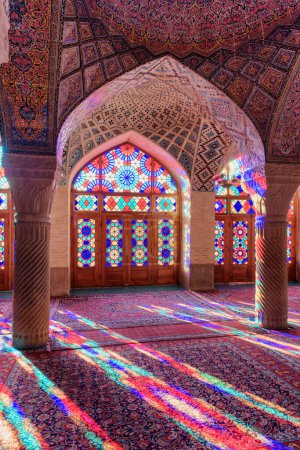 Foto de Shiraz, Irán - 31 de octubre de 2018: Vista inusual de la luz del sol matutino reflejada a través de vidrieras en columnas, la pared y el piso de la sala de oración en la Mezquita Nasir al-Mulk (Mezquita Rosa)). - Imagen libre de derechos