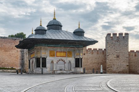 Foto de Impresionante vista de la Fuente del Sultán Ahmed III en la gran plaza frente a la Puerta Imperial del Palacio Topkapi en Estambul, Turquía. El quiosco de la fuente es una atracción turística popular en Turquía. - Imagen libre de derechos