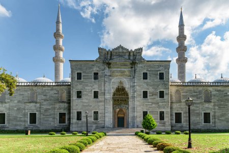 Foto de Impresionante vista de la puerta occidental de la Mezquita Suleymaniye desde los jardines circundantes en Estambul, Turquía. La mezquita imperial otomana es un destino popular entre los peregrinos y turistas del mundo. - Imagen libre de derechos