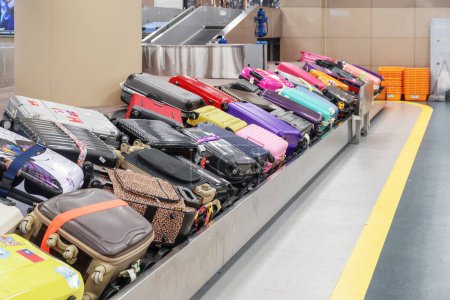 Téléchargez les photos : Busan, Corée du Sud - 6 octobre 2017 : Des valises et des sacs colorés sur la courroie transporteuse à l'aire d'arrivée de l'aérogare passagers de l'aéroport international de Gimhae. Carrousel à bagages. - en image libre de droit