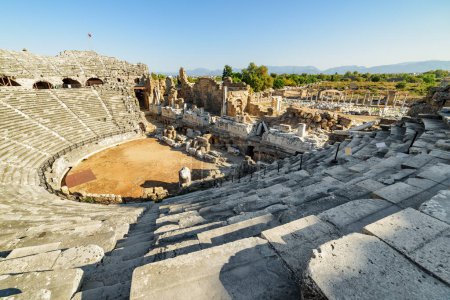 Foto de Aerial view of the ancient theatre in Side, Turkey. Drone flying around the scenic ruins. Side is a popular tourist destination in Turkey. - Imagen libre de derechos