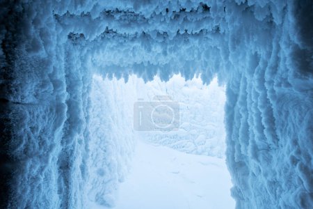 Foto de Invierno Fondo de Navidad de crecimientos de nieve congelados en el techo y la pared de la cueva de nieve. Vacaciones de invierno fondo de textura de nieve congelada - Imagen libre de derechos