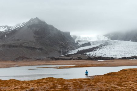 Téléchargez les photos : Touriste solitaire près de la lagune glaciaire de Vatnajokull. Parc national de Vatnajokull, sud-est de l'Islande, Europe. Photographie de paysage - en image libre de droit