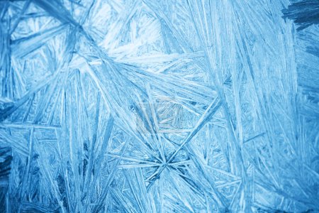 Téléchargez les photos : Fond de Noël avec motif congelé sur verre de fenêtre. Texture bleue réelle du gel des neiges hivernal - en image libre de droit