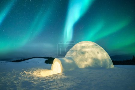 Téléchargez les photos : Aurora borealis. aurores boréales dans les montagnes hivernales. Scène hivernale avec lumières polaires éclatantes et igloo enneigé. Voitures de Noël - en image libre de droit
