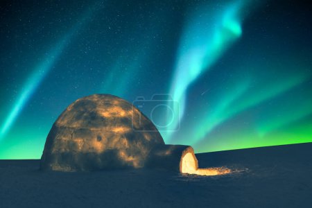Foto de Aurora borealis. Northern lights in winter mountains. Wintry scene with glowing polar lights and snowy igloo. Christmas postcars - Imagen libre de derechos