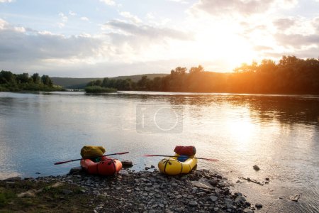Photo for Orange and yellow packrafts rubber boats with padles on a sunrise Dnister river. Packrafting background. Active lifestile concept - Royalty Free Image
