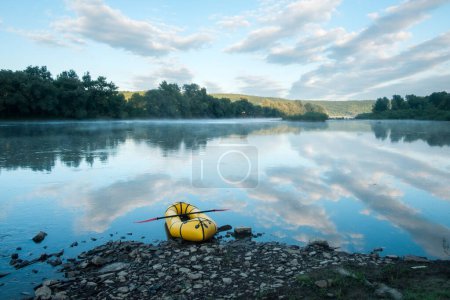 Photo for Yellow rubber boat packraft with red padle on beautiful sunrise river. Packrafting background. Active lifestile concept - Royalty Free Image
