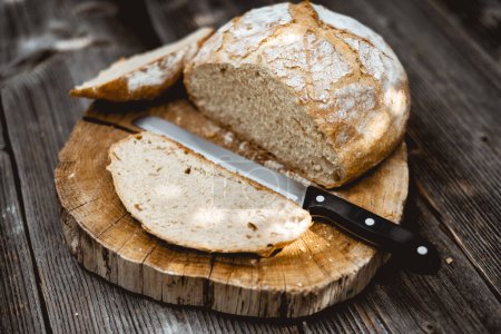 Photo for Traditional sourdough bread, sliced and ready to eat on the rustic wooden table. This photo captures the essence of healthy food photography - Royalty Free Image