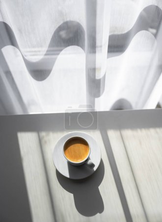 Foto de Taza de café expreso en la mesa cerca de la ventana con luz de la mañana. Fotografía de alimentos y bebidas - Imagen libre de derechos