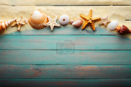 Téléchargez les photos : Vacations and summer time concept with starfish and sea shells on a turquoise wooden table with sand - en image libre de droit