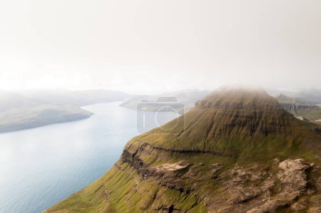 Photo for Foggy mountain peaks and clouds covering sea and mountains. Panoramical view from famous place - Sornfelli on Streymoy island, Faroe islands, Denmark. Landscape photography - Royalty Free Image