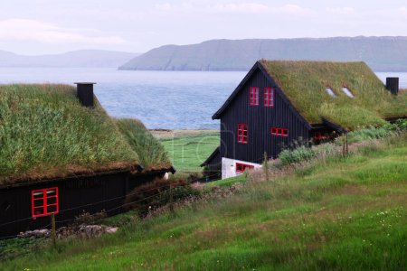 Foto de Vista brumosa de la mañana de una casa con techo de hierba en el pueblo de Velbastadur en la isla de Streymoy, Islas Feroe, Dinamarca. Paisaje fotografía - Imagen libre de derechos