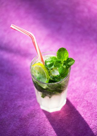Téléchargez les photos : Cocktail classique Mojito sur fond violet de près. Photographie alimentaire - en image libre de droit