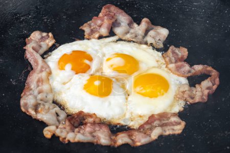 Foto de Desayuno con huevos fritos y tocino de cerca. Forografía alimentaria - Imagen libre de derechos