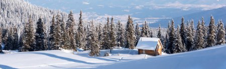 Foto de Un claro de montaña adornado con abetos cubiertos de nieve y una encantadora casa de madera en un entorno invernal. Invierno montañas paisaje panorama - Imagen libre de derechos