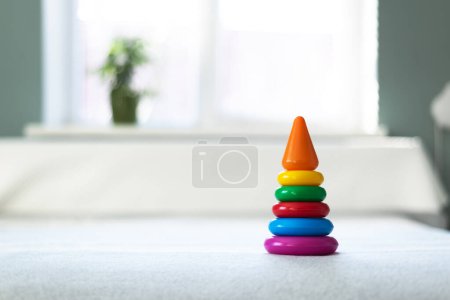 Photo for Multi-colored plastic pyramid toy in child playing room. Happy childhood concept - Royalty Free Image
