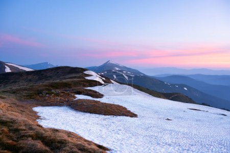 Téléchargez les photos : Matin dans les montagnes printanières avec des collines enneigées et un ciel rose levant. Carpates ukrainiens. Photographie de paysage - en image libre de droit