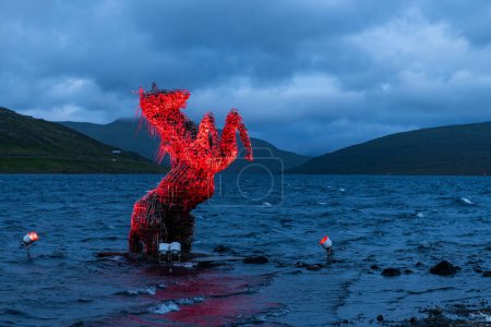Nykur Nix Estatua en el lago Sorvagsvatn cerca del aeropuerto de Vagar, Islas Feroe, Dinamarca. Caballo mítico luminoso rojo