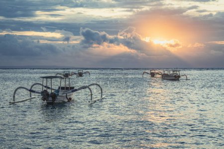 Photo for Bali island, Indonesia. Sunset scenery. Summer vacation. Fishing boats floating on the ocean. Wooden boat sailing in open waters. Sailing boat landscape. - Royalty Free Image