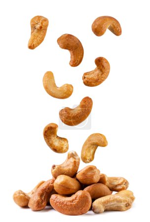 Roasted cashew nuts fall on a pile close-up on a white background. Isolated