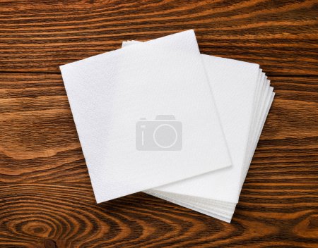 Foto de Servilletas de papel blanco sobre fondo de madera. Vista superior - Imagen libre de derechos