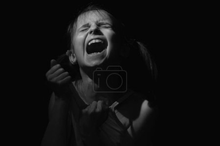 Photo for Conceptual image: autoaggression of child. Psychological portrait of sad and depressed young girl. Black and white image. - Royalty Free Image