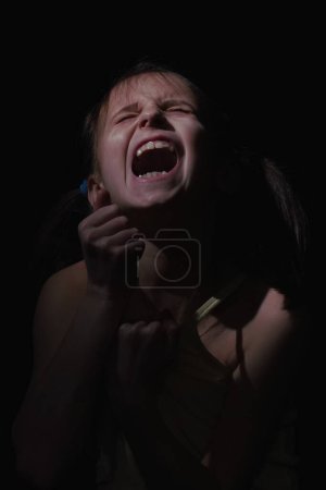 Conceptual image: autoaggression of child. Psychological portrait of sad and depressed young girl. Vetical image.