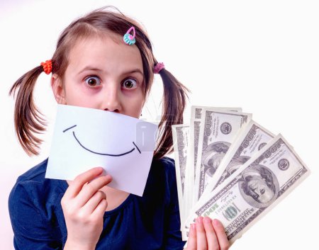 Conceptual image of young girl holding US Dollar money and banner with fake smile as symbol: money can't buy happiness. Horizontal image.