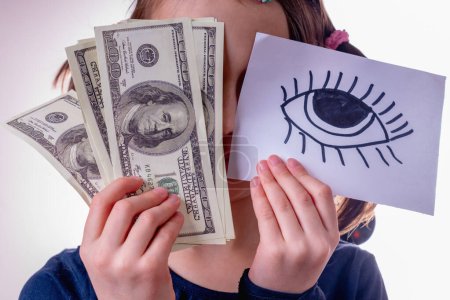 Conceptual portrait of young girl holding US Dollar money and banner with open eye as symbol: money can buy happiness