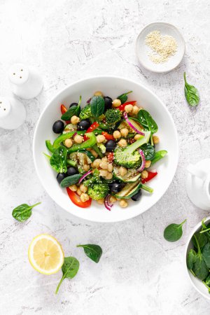 Photo for Chickpea and spinach vegan vegetable salad with broccoli, sweet pepper, olives and grilled zucchini. Mediterranean diet, healthy food. Top view - Royalty Free Image