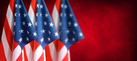 Foto de Tres banderas americanas frente a fondo borroso rojo - Imagen libre de derechos