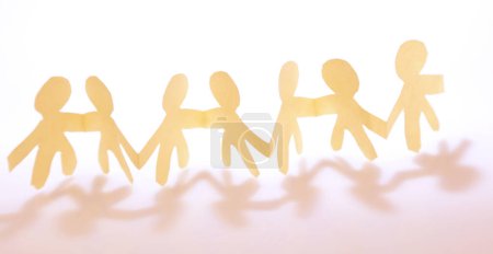Photo for Team of paper chain people united together holding hands - Royalty Free Image