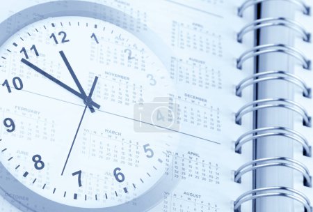 Foto de Reloj cara y calendario diario de la página. Gestión del tiempo - Imagen libre de derechos