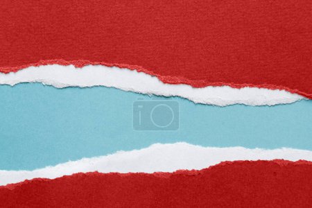 Foto de Agujero rasgado en papel rojo sobre fondo azul. Copiar espacio - Imagen libre de derechos