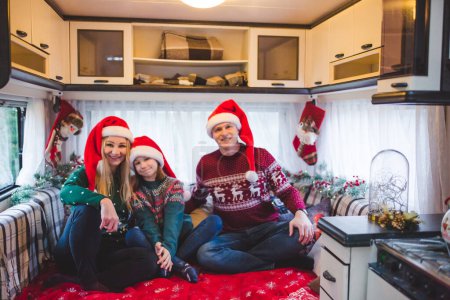 Photo for Young caucasian family having fun in camper with Christmas decorations - Royalty Free Image