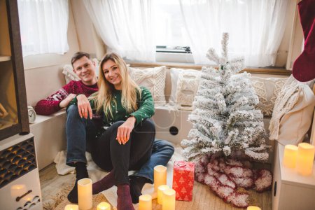 Photo for Young caucasian couple having fun in camper with Christmas decorations - Royalty Free Image