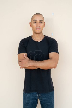 Téléchargez les photos : Portrait of handsome bald man wearing t-shirt against plain background - en image libre de droit