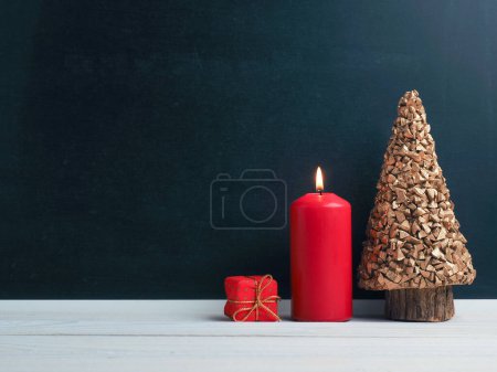 First Advent candle burning with Christmas decoration on a chalkboard, seasonal or holiday background