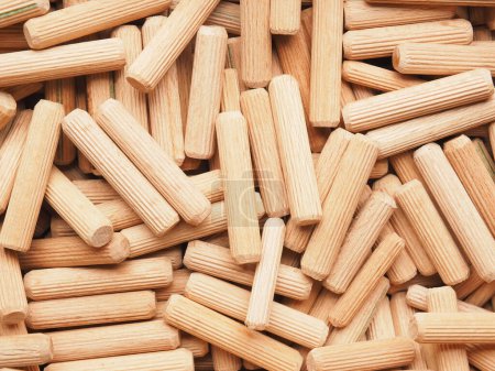 Pile of wooden dowels using as background or header, wood working or workshop concept