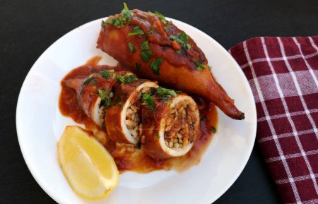 Foto de Un plato de sabrosos calamares rellenos de arroz y verduras en salsa de tomate - Imagen libre de derechos