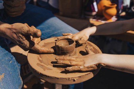 Teaching pottery to children. A master teaches a child pottery. Children's pottery studio