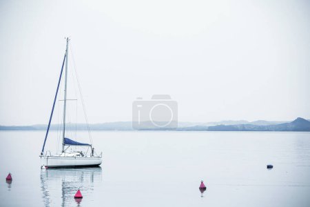 Téléchargez les photos : Yacht on Lake Garda on a spring day with mountains in the background - en image libre de droit