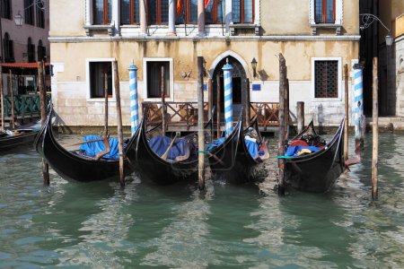  Mehrere Gondeln liegen in den Kanälen Venedigs, umgeben von malerischen mittelalterlichen Gebäuden.