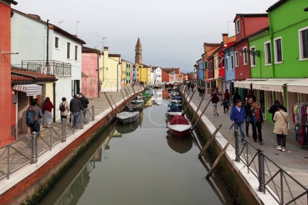 Photo for BURANO, ITALY - APRIL 29, 2019: Burano island, typical street canal and multi-colored houses of locals. Burano the island - one of famous tourist objects in the Venetian lagoon - Royalty Free Image
