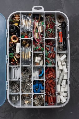 Photo for Open Organizer for storing various electronic components and equipment. plastic box for convenient storage of small radio components and other small items, on gray concrete background - Royalty Free Image