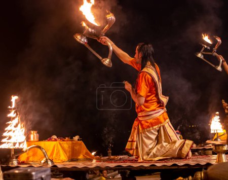 Foto de Varanasi, India - 01 de octubre de 2014: Un sacerdote hindú realiza el ritual Ganga Aarti durante Varanasi.Fire puja es un ritual hindú que tiene lugar en Dashashwamedh Ghat a orillas del río Ganges. - Imagen libre de derechos
