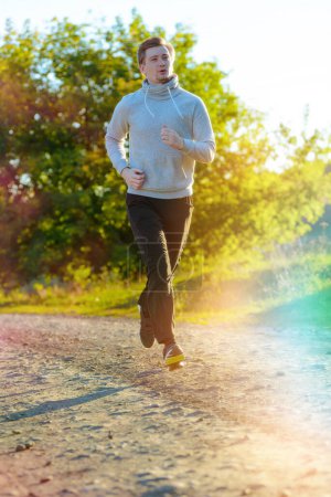 Photo for Running man jogging in rural nature at beautiful summer day. Sport fitness model caucasian ethnicity training outdoor. - Royalty Free Image