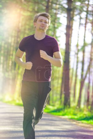 Photo for Running man jogging in city park at beautiful summer day. Sport fitness model caucasian ethnicity training outdoor. - Royalty Free Image